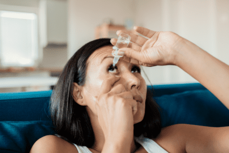 woman treating dry eyes with eye drops